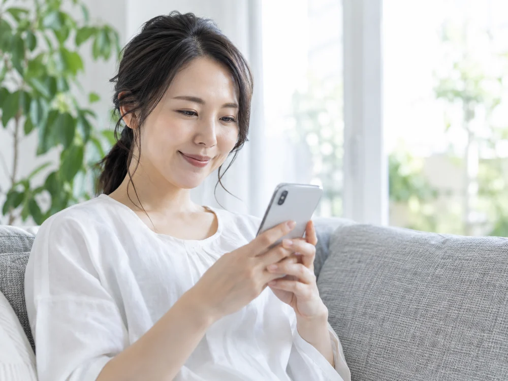 自宅でスマートフォンを使う女性